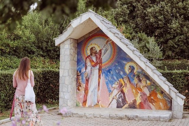 Image of a woman in front of religious fresco