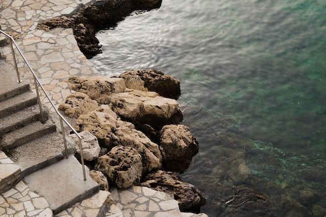 Stairs beside body of water during the day