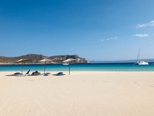 Photo of Elafonissos beach landscape and sailboat